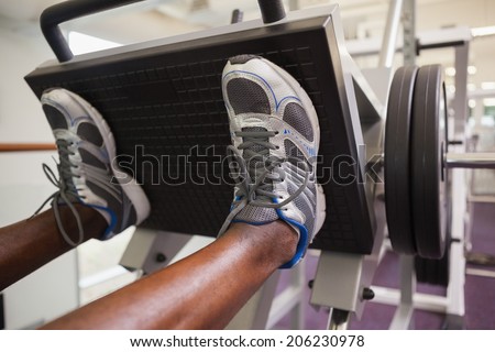 Close up of male weightlifter doing leg presses in gym