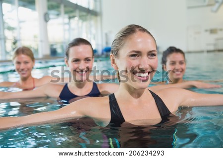 Female fitness class doing aqua aerobics in swimming pool at the leisure centre