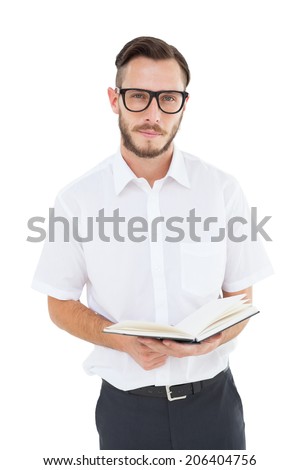 Geeky young man reading from black book on white background