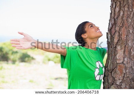 Pretty environmental activist looking up at tree on a sunny day in the countryside