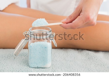 Close up of a hand using salt scrub at spa center