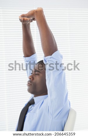 Relaxed businessman stretching in his chair in his office