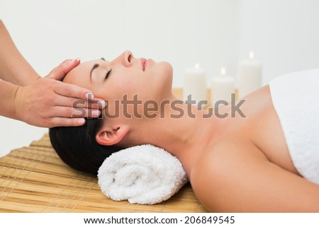 Peaceful brunette enjoying a facial massage in the health spa