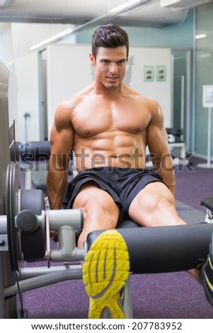 Determined young muscular man doing a leg workout at the gym