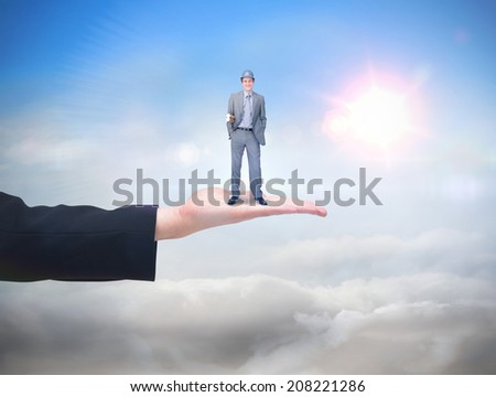 Smiling attractive architect on phone holding plans against blue sky with sunshine and clouds