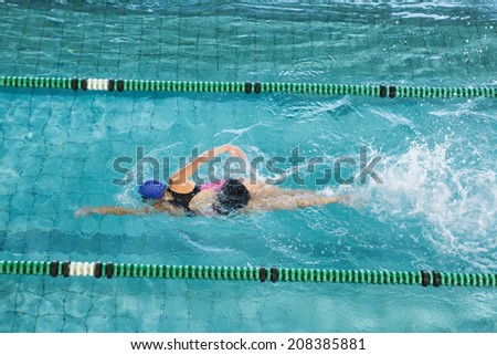 Fit swimmer training by herself in swimming pool at the leisure centre