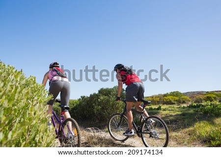 Active couple cycling in the countryside on a sunny day