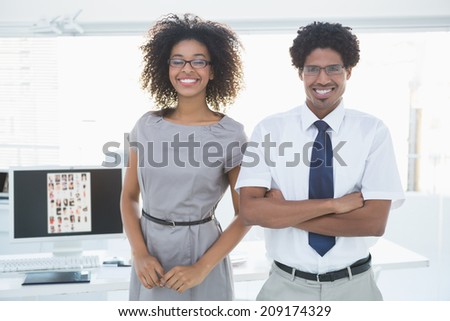 Young editorial team smiling at camera together in creative office