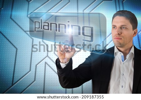 Businessman pointing to word planning against circuit board on futuristic background
