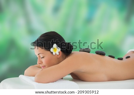 Beautiful brunette relaxing on massage table at a luxury spa