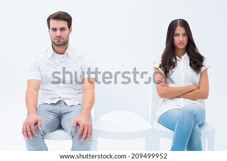 Angry couple not talking after argument on white background