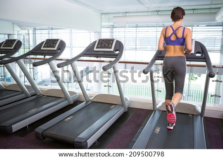 Fit brunette running on the treadmill at the gym
