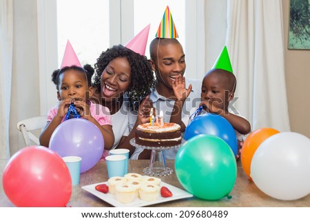 Happy family celebrating a birthday together at table at home in the kitchen