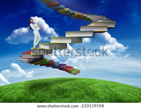 Side view of young woman carrying a pile of books against green field under blue sky
