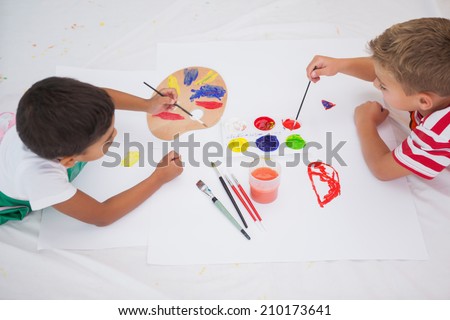 Cute little boys painting on floor in classroom at the nursery school