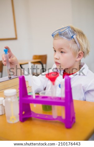 Cute pupil dressed up as scientist in classroom at the elementary school