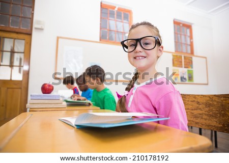 Cute pupils reading at desks at the elementary school
