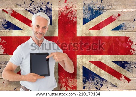 Mature student showing tablet pc against union jack flag in grunge effect