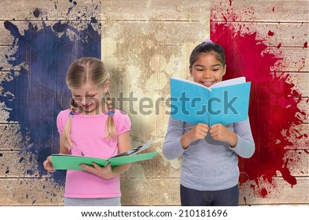 Elementary pupils reading against france flag in grunge effect