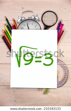 Square root of three against students desk with white page