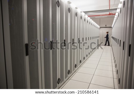 Technician walking in server hallway in large data center