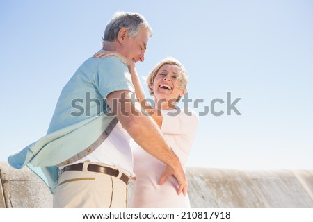 Senior woman hugging her partner on a sunny day