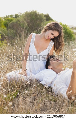 Relaxed young couple sitting on countryside landscape