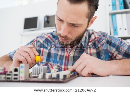 Computer engineer working on cpu with screwdriver in his office