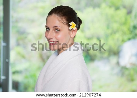 Portrait of a beautiful young woman in bathrobe against blurred plants