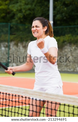 Pretty tennis player celebrating a win on a sunny day