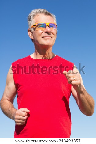 Active senior man jogging on the pier on a sunny day
