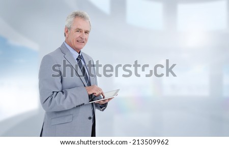 Side view of mature tradesman with tablet computer against bright white room with windows