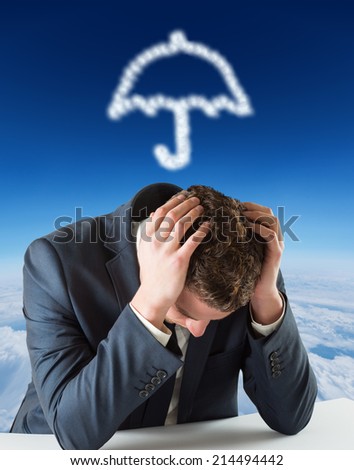 Businessman with head in hands against blue sky over clouds at high altitude