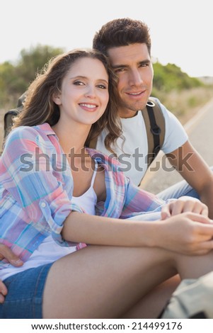 Portrait of hiking young couple sitting on countryside road