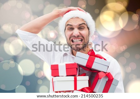 Festive man holding christmas gifts against light glowing dots design pattern