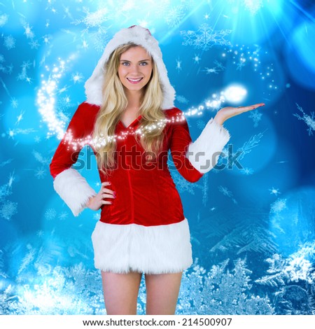 Pretty girl presenting in santa outfit against blue snow flake pattern design