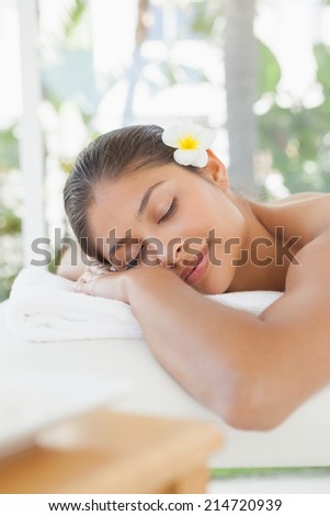 Beautiful brunette relaxing on massage table at the health spa