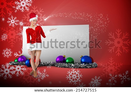 Pretty santa girl presenting with hand against red snow flake pattern design