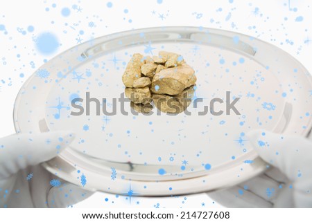 Golden nuggets on a silver tray against snow falling