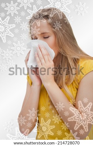 Close up of a blond woman blowing against snowflakes on silver