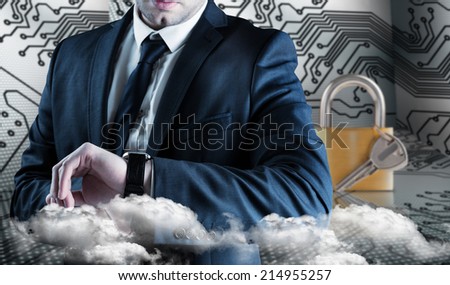 Businessman checking the time on watch against digital circuit board and locked padlock