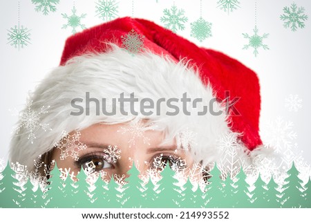 Close up portrait of pretty woman in santa hat against snowflakes and fir trees in green