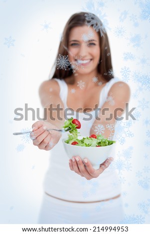 Delicious salad being eaten by a young woman against snow falling