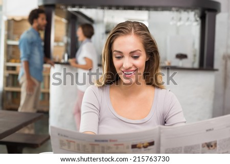 Pretty blonde reading the newspaper at the coffee shop