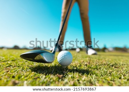 Low section of african american young man aiming ball with club at golf course against clear sky. copy space, summer, golf, unaltered, sport and weekend activities concept. 商業照片 © 