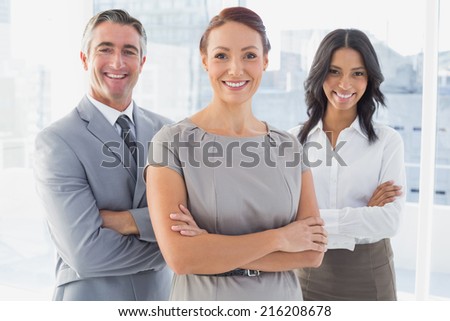 Businesswoman smiling with folded arms at work