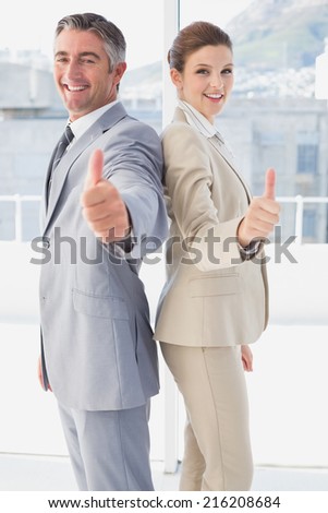 Employee's giving a thumb's up while standing back to back