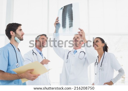 Doctor holding up an x-ray with fellow doctors