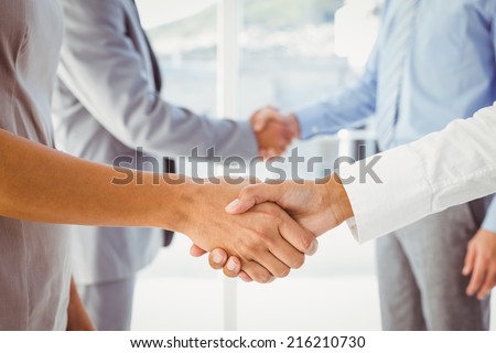 Two fellow employees shaking hands at work