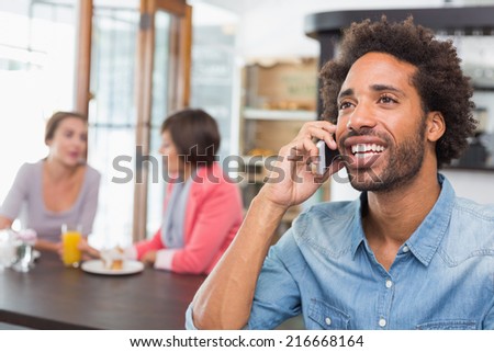 Handsome man talking on the phone at the coffee shop